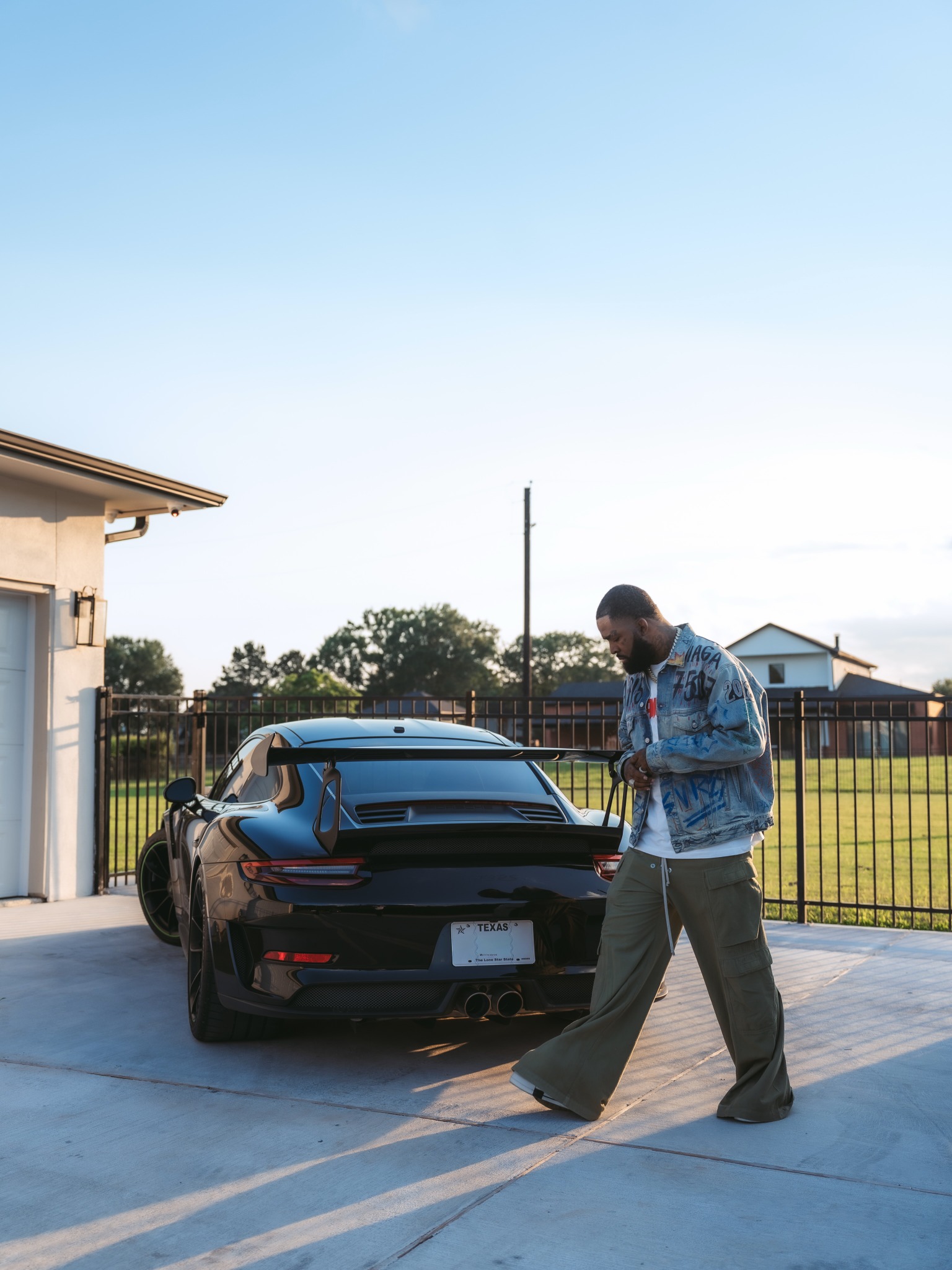 Brodie Fresh walking beside a black sports car